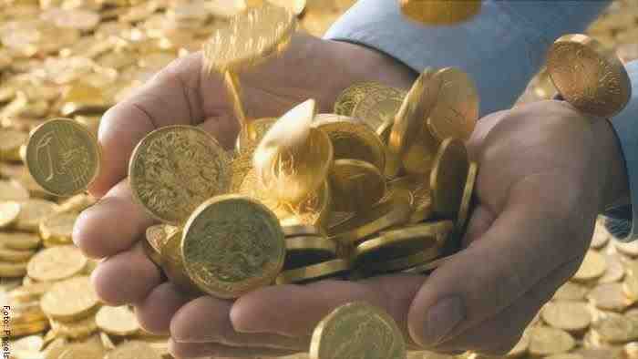 Foto di mani che tengono monete d'oro