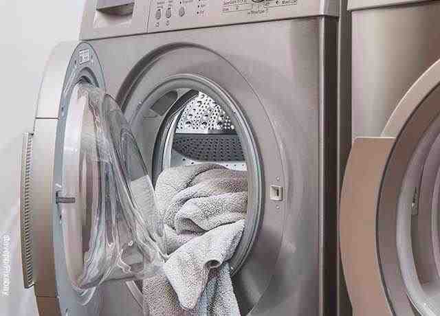 La foto di una lavatrice aperta con un asciugamano rivela cosa significa sognare di lavare i vestiti.